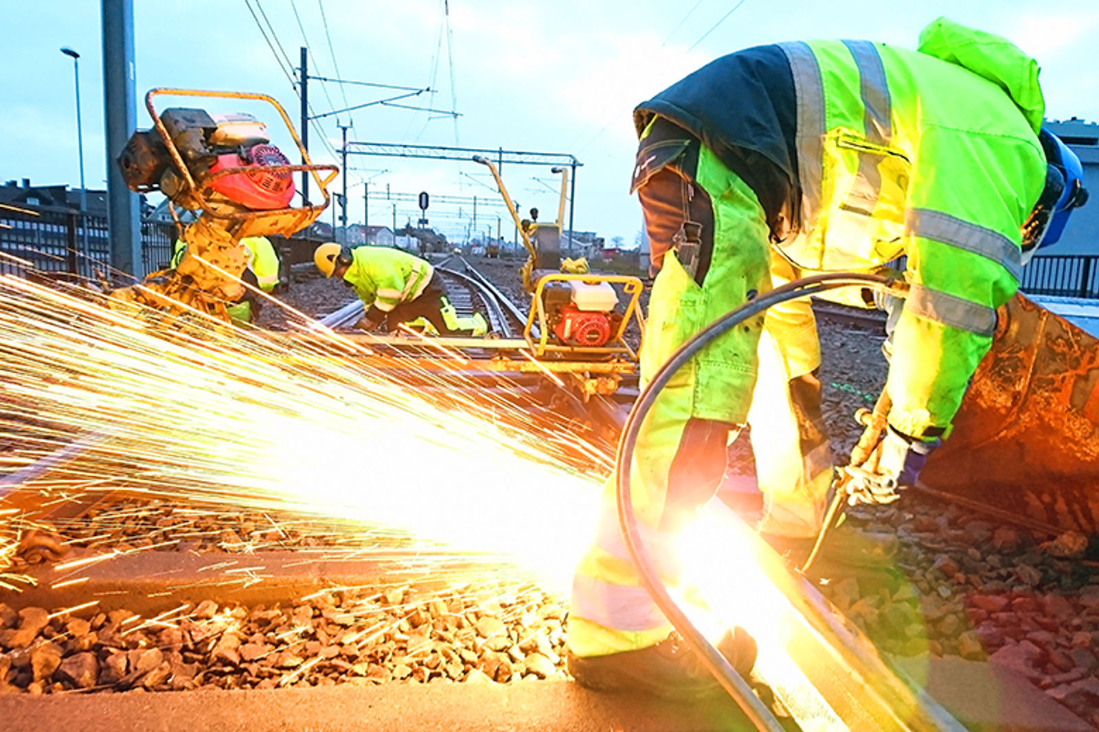 Bilde av folk som sveiser i skinnegangen, så gnistene flyr.