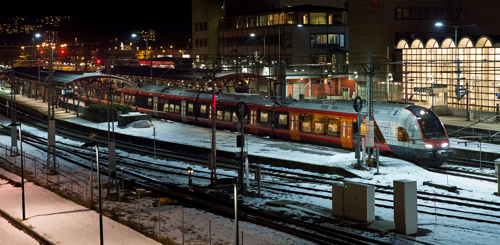 Tog på jernbanestasjon i mørke